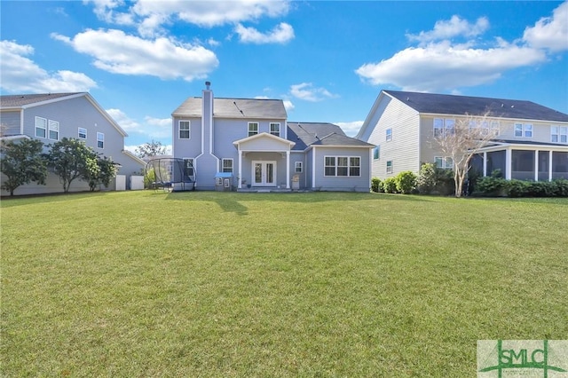 rear view of property with a lawn and a chimney