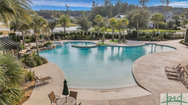 view of pool featuring a pool with connected hot tub and a patio