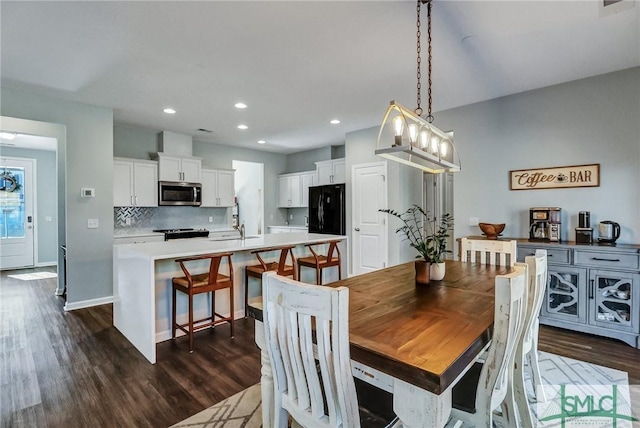 dining room with baseboards, dark wood-style flooring, and recessed lighting