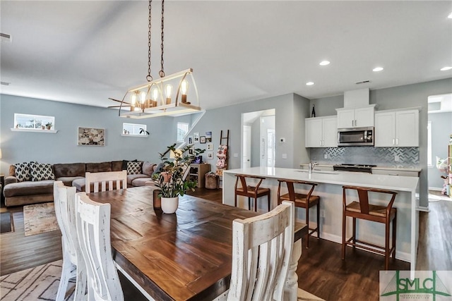 dining area featuring plenty of natural light, visible vents, dark wood-type flooring, and recessed lighting