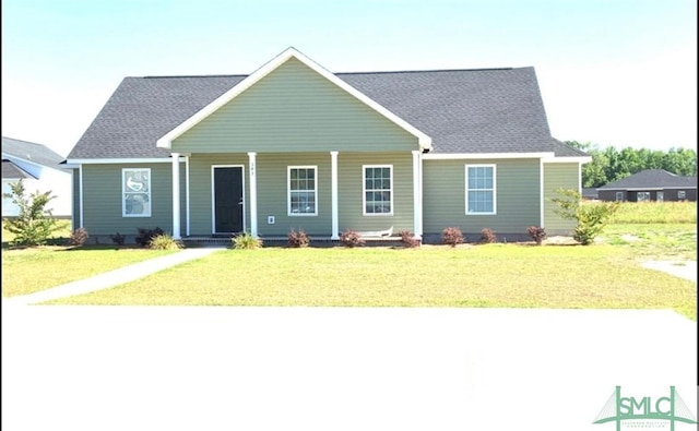 view of front of property with a shingled roof, a front yard, and covered porch