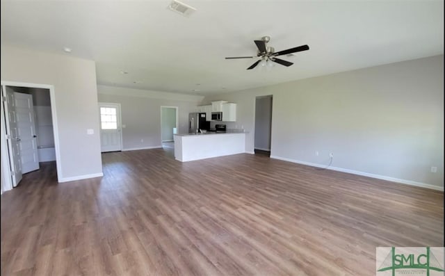 unfurnished living room with baseboards, ceiling fan, visible vents, and wood finished floors