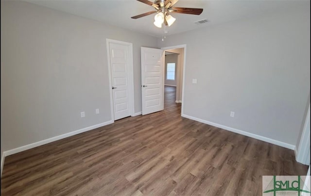 unfurnished bedroom with ceiling fan, wood finished floors, visible vents, and baseboards