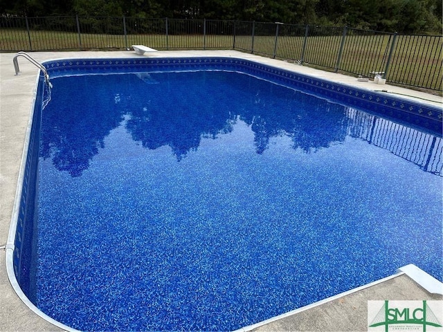 view of swimming pool with a fenced in pool, fence, and a diving board