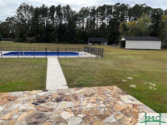 view of pool with a fenced in pool, a lawn, an outbuilding, fence, and a shed