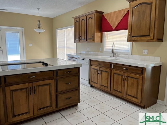 kitchen featuring black electric stovetop, tile counters, visible vents, a sink, and dishwasher