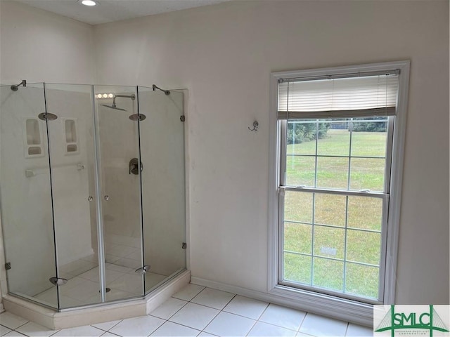 bathroom with a stall shower, tile patterned flooring, and baseboards