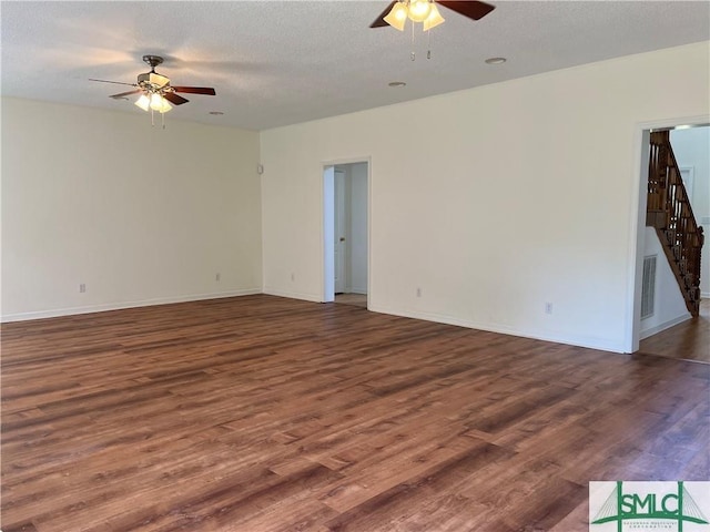 unfurnished room featuring baseboards, visible vents, ceiling fan, wood finished floors, and a textured ceiling