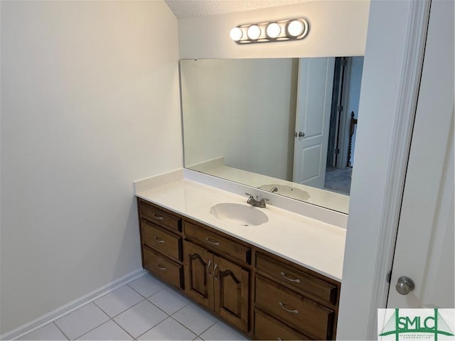 bathroom featuring tile patterned flooring, baseboards, a textured ceiling, and vanity