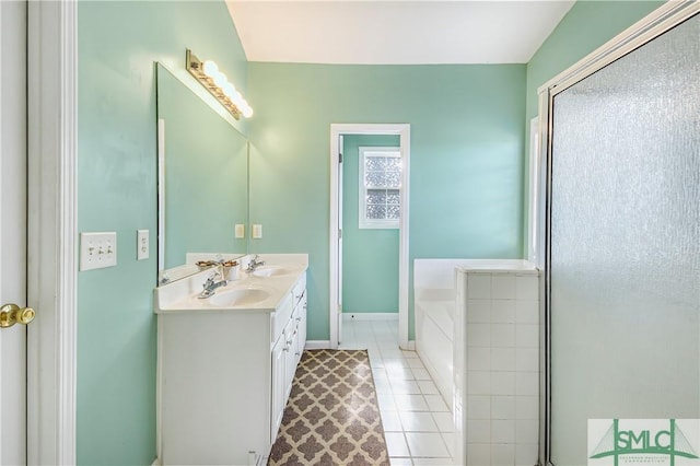 full bath with a bath, double vanity, baseboards, and a sink