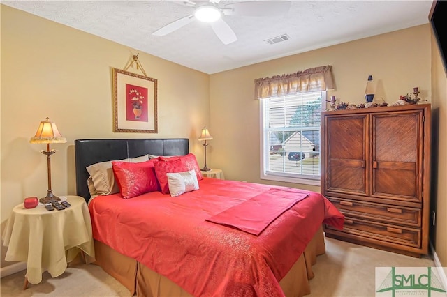 carpeted bedroom featuring visible vents and a ceiling fan