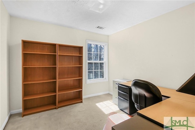 office featuring baseboards, visible vents, and light colored carpet