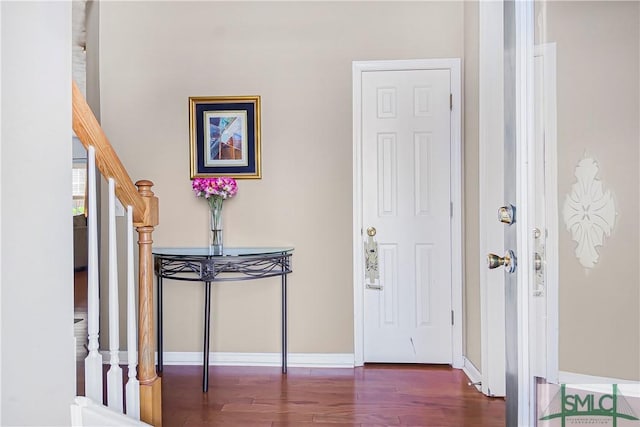 foyer entrance featuring stairs, baseboards, and wood finished floors