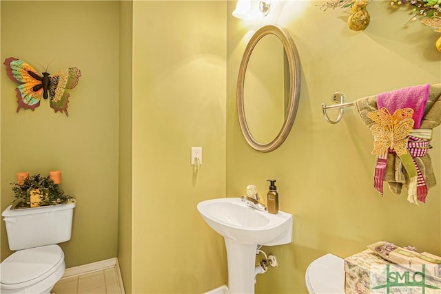 bathroom featuring baseboards, toilet, and tile patterned floors