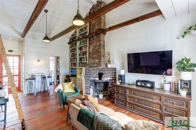 living area with hardwood / wood-style floors and beam ceiling