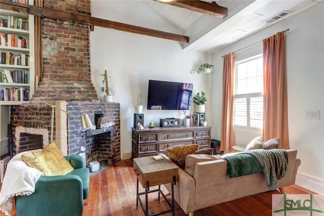 living area featuring visible vents, baseboards, wood-type flooring, vaulted ceiling with beams, and a fireplace