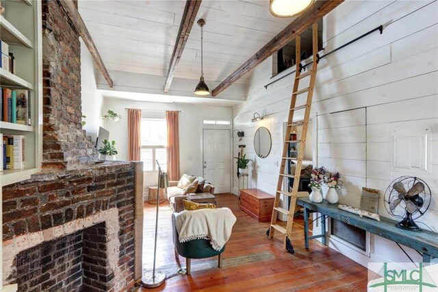 interior space featuring wood-type flooring, a fireplace, and beam ceiling