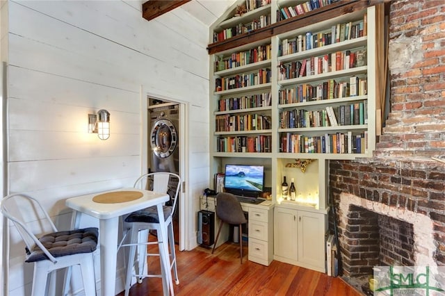 office with wood finished floors, built in study area, and wooden walls