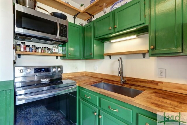 kitchen featuring stainless steel appliances, wooden counters, a sink, and open shelves