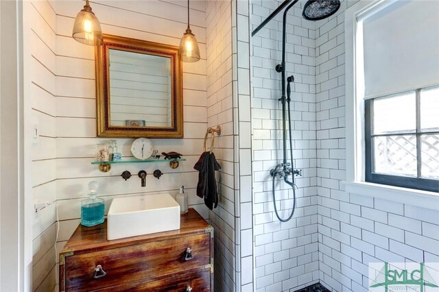 bathroom featuring tiled shower and vanity