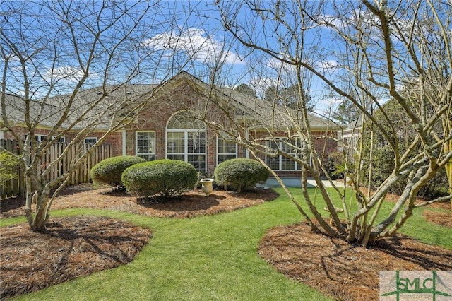 exterior space with brick siding and a front yard