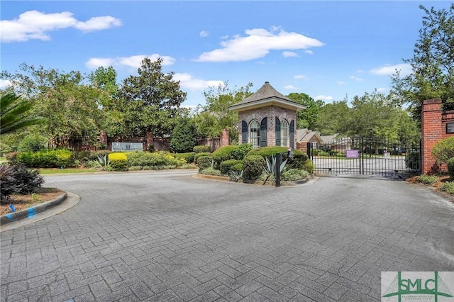 view of street featuring curbs, a gated entry, and a gate