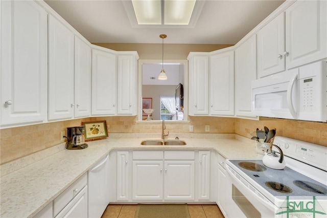 kitchen with white appliances, tasteful backsplash, white cabinets, and a sink