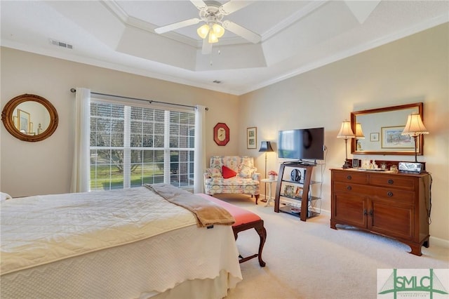 bedroom with ornamental molding, visible vents, a raised ceiling, and light colored carpet