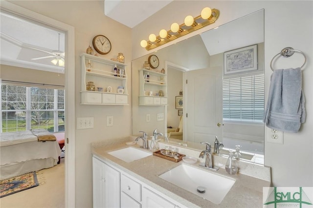 ensuite bathroom with double vanity, ensuite bath, a sink, and a ceiling fan