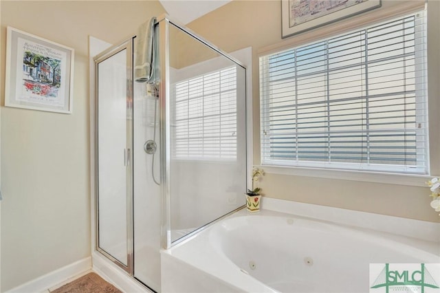 bathroom featuring a jetted tub, a stall shower, and a wealth of natural light