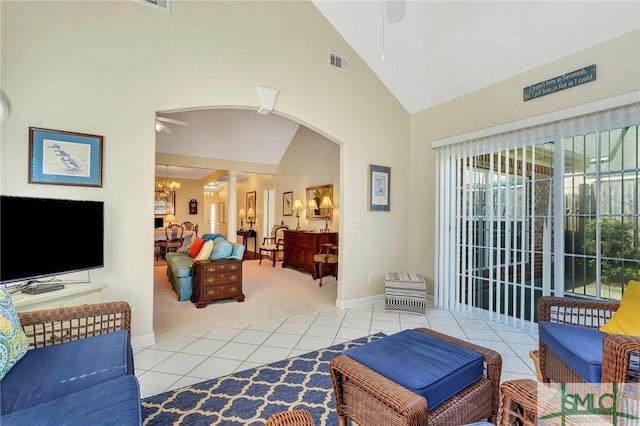 living area featuring arched walkways, visible vents, light tile patterned flooring, ceiling fan, and ornate columns