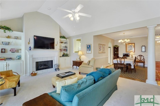 living room with lofted ceiling, built in shelves, a tile fireplace, carpet floors, and ornate columns