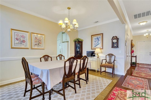 dining area with a chandelier, arched walkways, visible vents, and light tile patterned floors