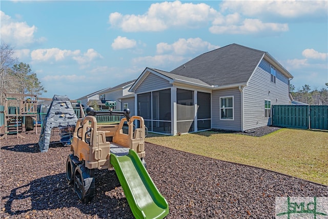 exterior space featuring a yard, fence, and a sunroom