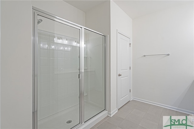 full bath with a shower stall, baseboards, and tile patterned floors