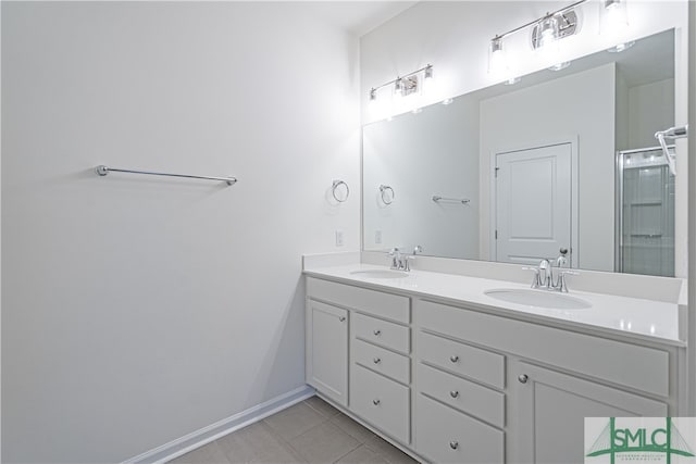 full bath featuring double vanity, an enclosed shower, a sink, and tile patterned floors