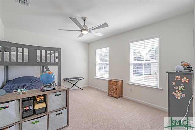 bedroom with light carpet, a ceiling fan, visible vents, and baseboards