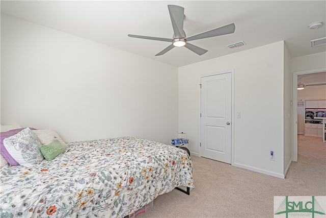 bedroom with a ceiling fan, light colored carpet, visible vents, and baseboards