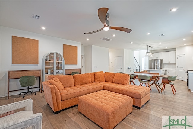 living room featuring light wood-style floors, visible vents, a ceiling fan, and recessed lighting