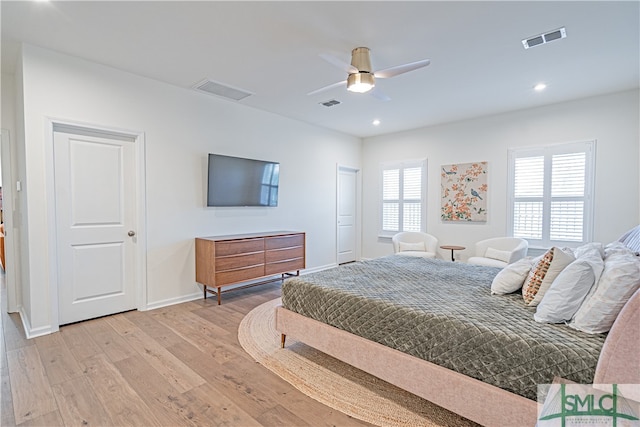 bedroom featuring light wood-style flooring, visible vents, and baseboards