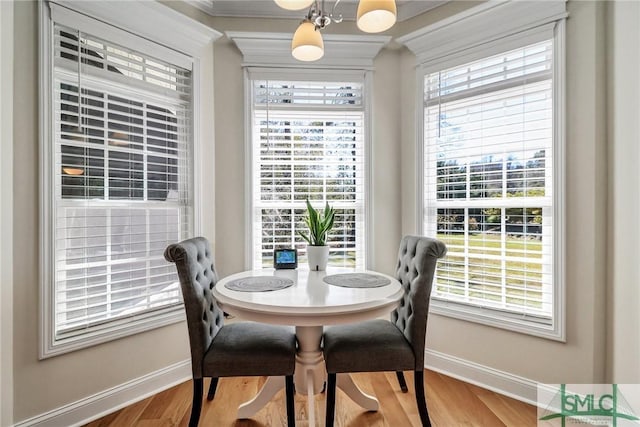 dining area featuring baseboards, a chandelier, and wood finished floors