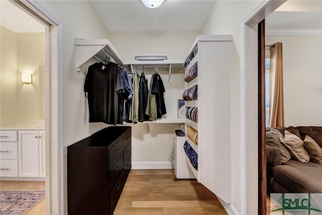 mudroom featuring crown molding, light wood-style flooring, and baseboards