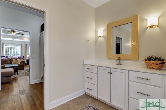 bathroom featuring ensuite bathroom, wood finished floors, a ceiling fan, vanity, and baseboards