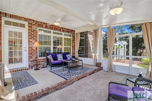 sunroom featuring beamed ceiling and a ceiling fan