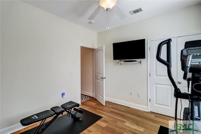 exercise room with a ceiling fan, visible vents, light wood-style flooring, and baseboards