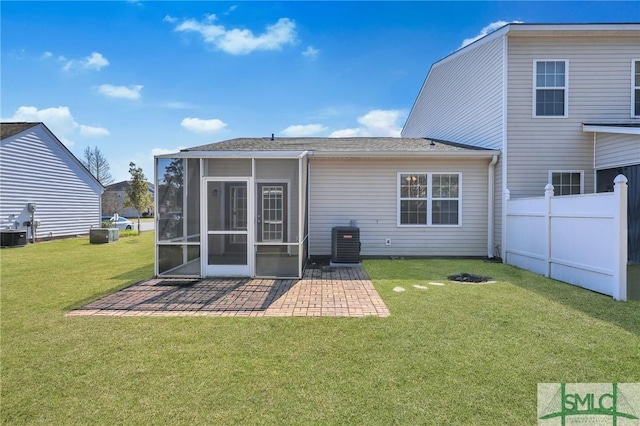 rear view of property with central AC, fence, a sunroom, a lawn, and a patio area