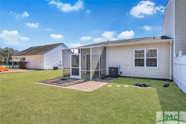 rear view of house featuring a sunroom, fence, cooling unit, and a lawn