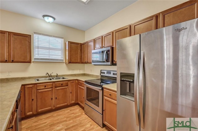 kitchen with stainless steel appliances, a sink, and brown cabinets