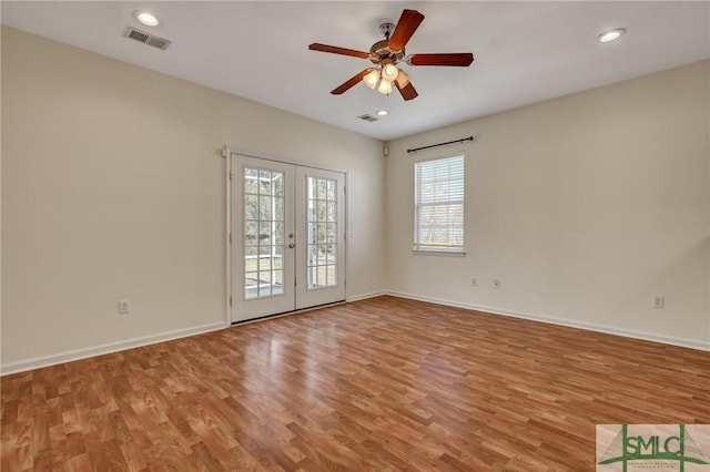 empty room with light wood-style flooring, visible vents, baseboards, and french doors