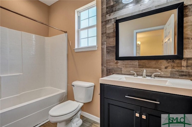 bathroom featuring toilet, washtub / shower combination, baseboards, and vanity